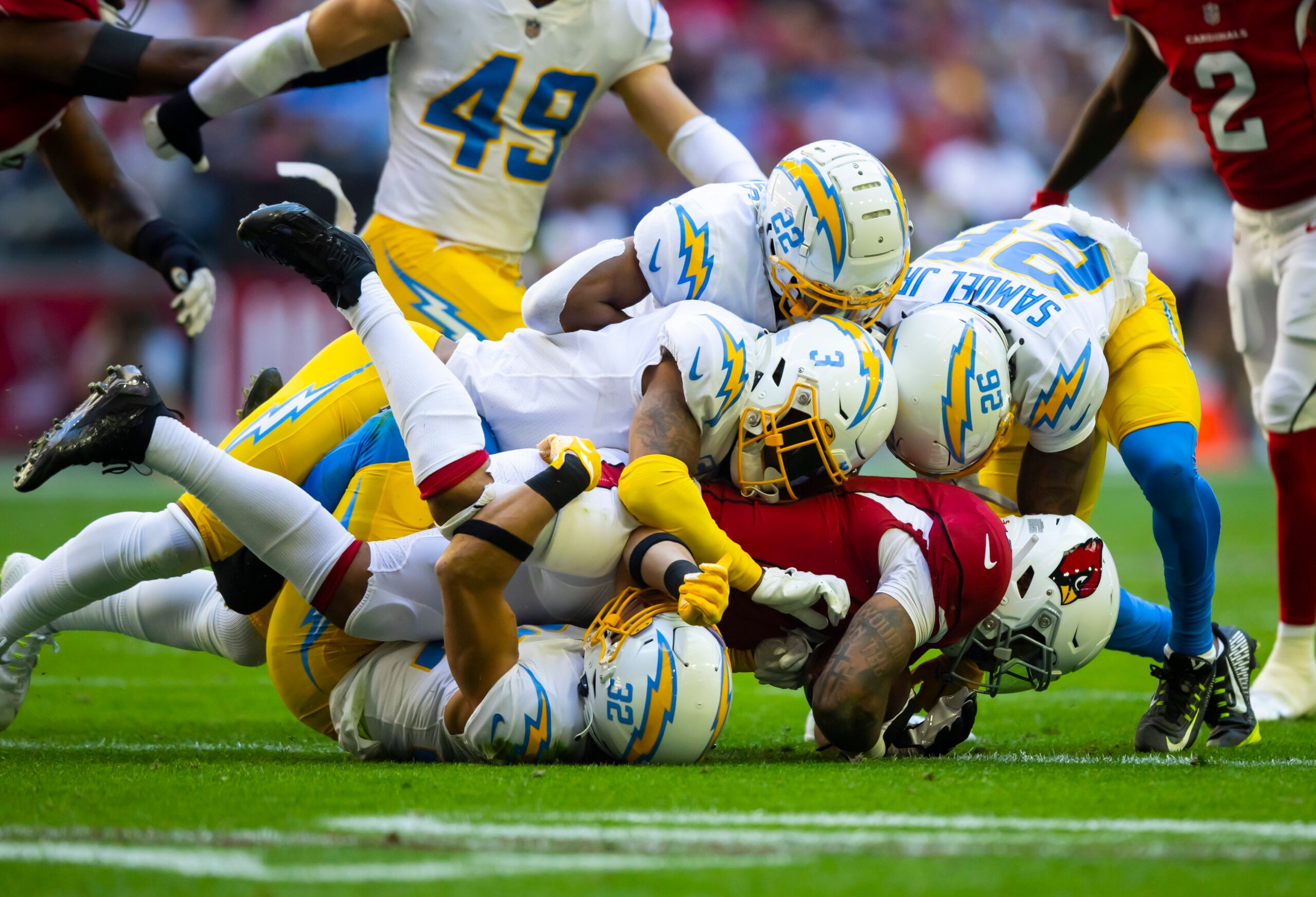 James Conner brought down by multiple Chargers defenders during the Cardinals-Chargers game at State Farm Stadium.