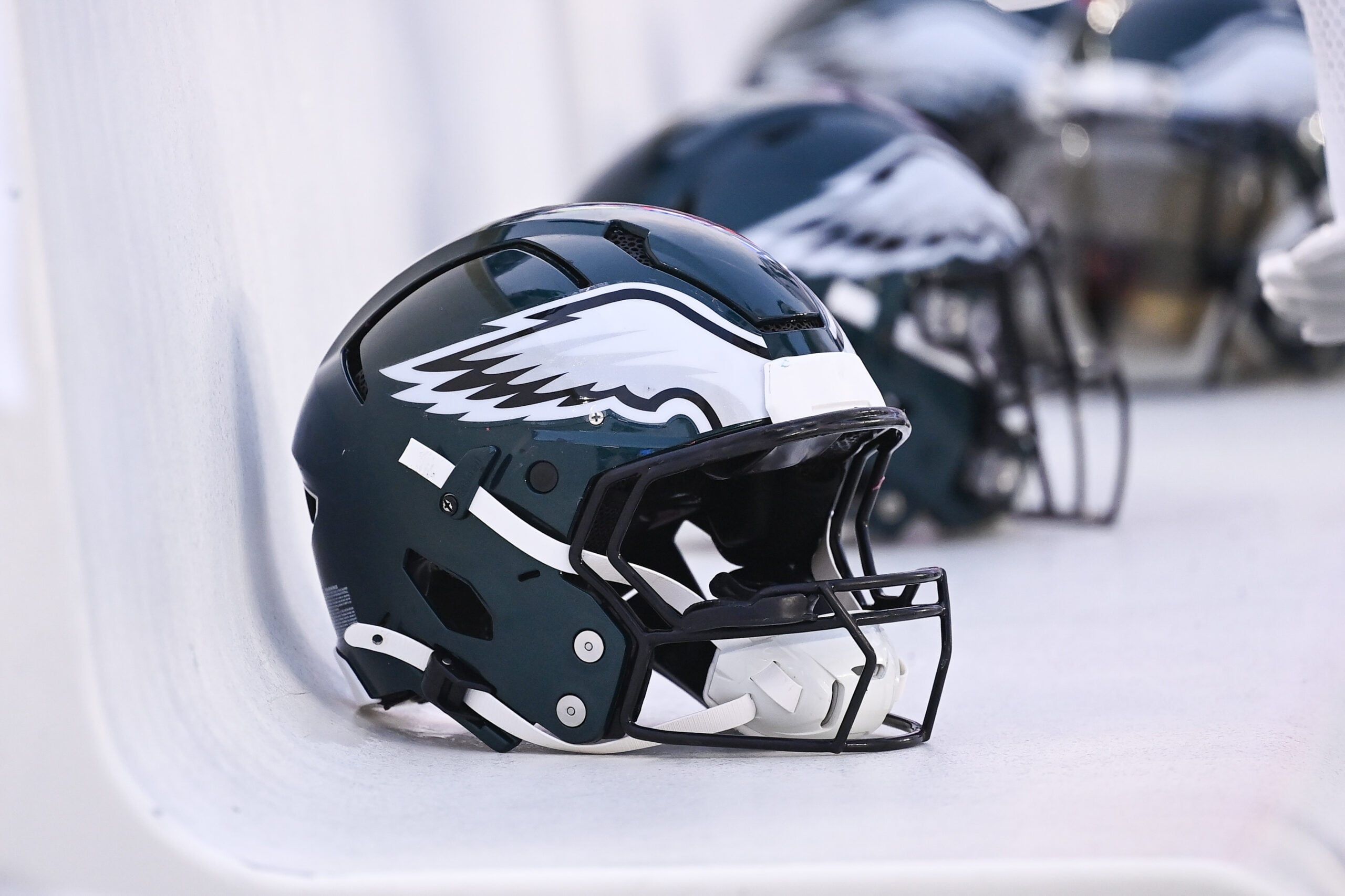 Philadelphia Eagles helmets lined up on the bench at Gillette Stadium.