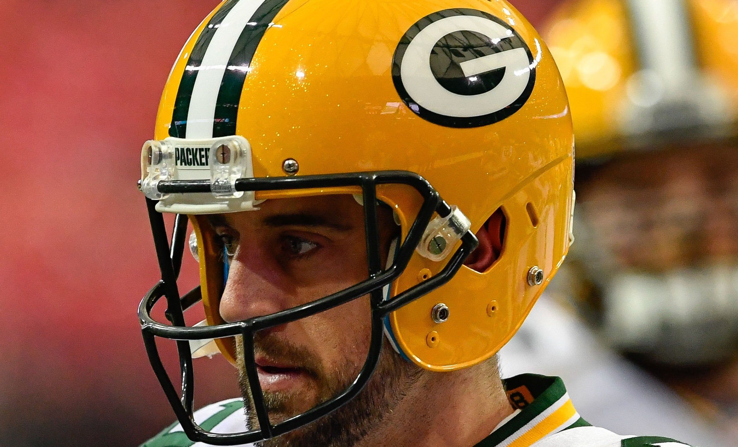 Aaron Rodgers stands on the field before a road game in Atlanta