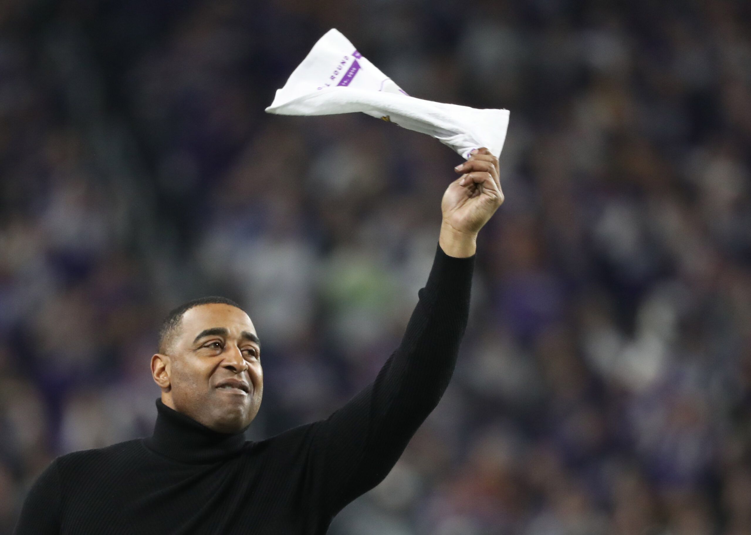 Cris Carter waves a towel on the sideline during a Vikings playoff game.