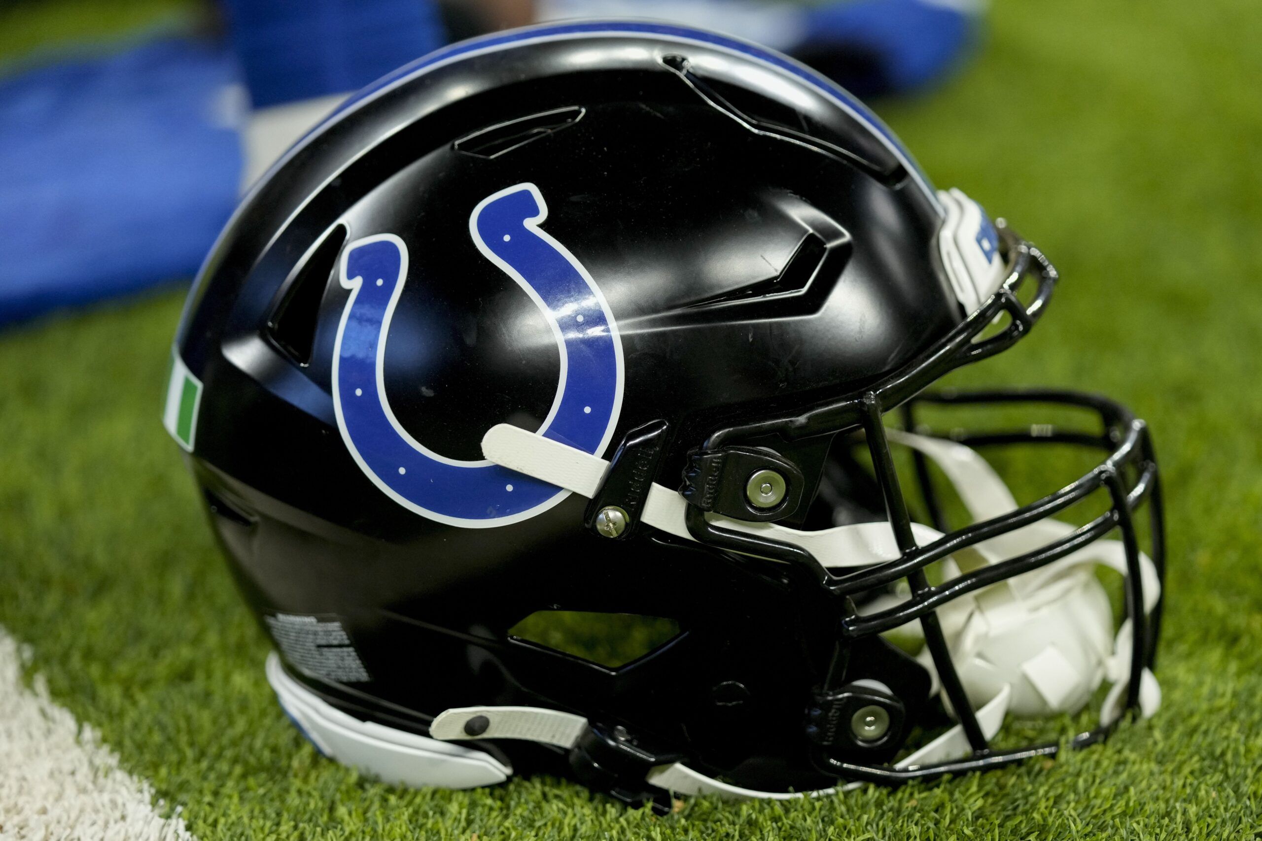 A black Indianapolis Colts helmet sits on the turf before the Colts-Lions game at Lucas Oil Stadium.