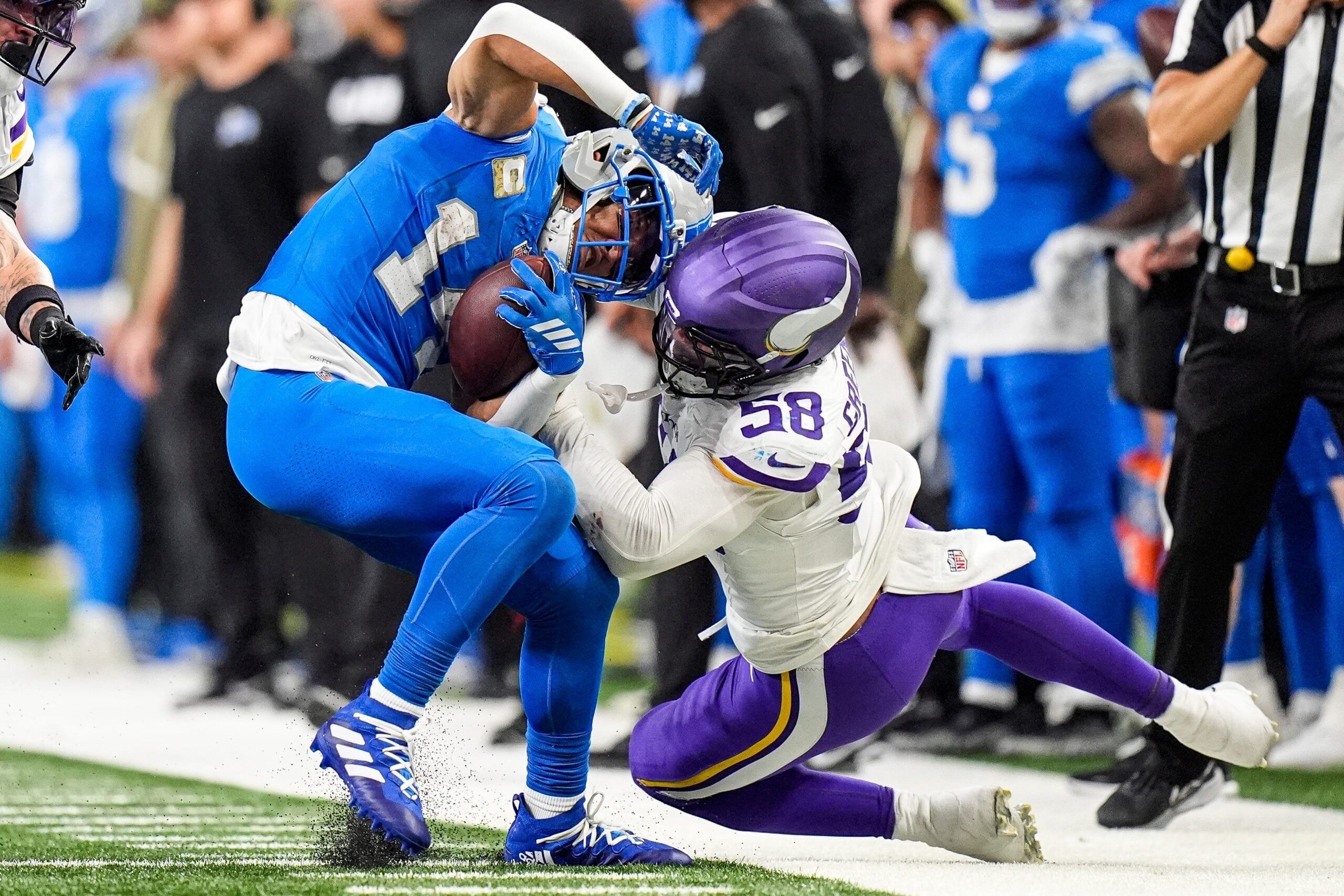 Amon-Ra St. Brown catching a pass while Jonathan Greenard defends during a Lions vs Vikings game