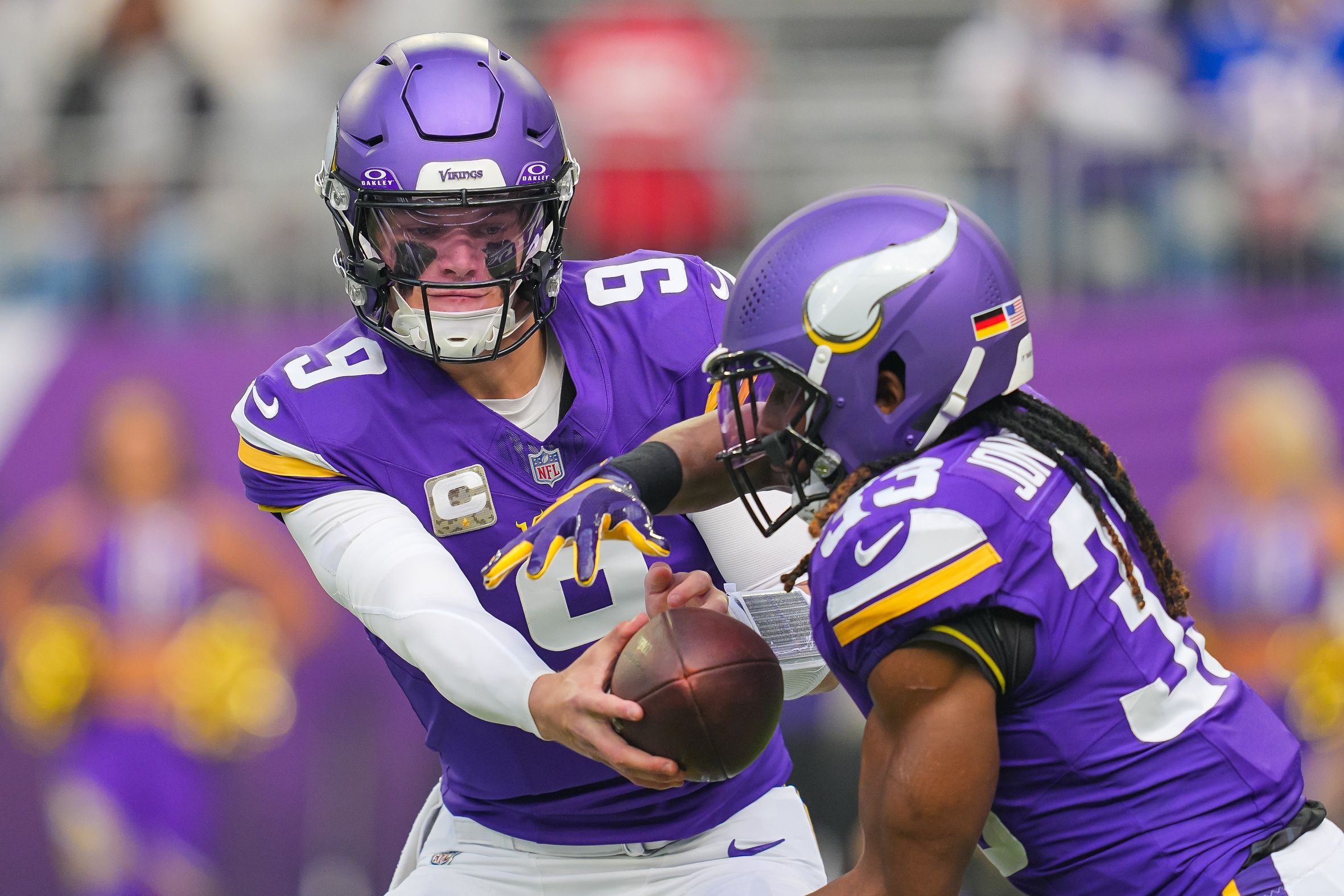 J.J. McCarthy hands the ball to Aaron Jones during a Vikings game against the Ravens at U.S. Bank Stadium.