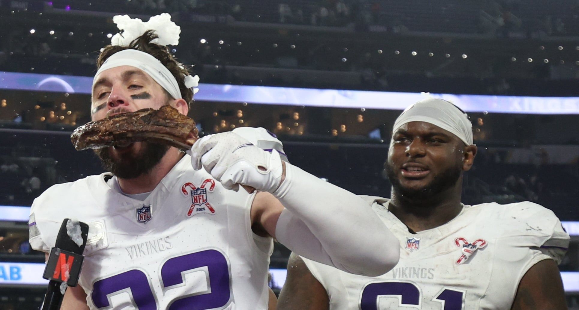 Harrison Smith eats a steak while being interviewed by Dianna Russini on the field at U.S. Bank Stadium after a Vikings game.