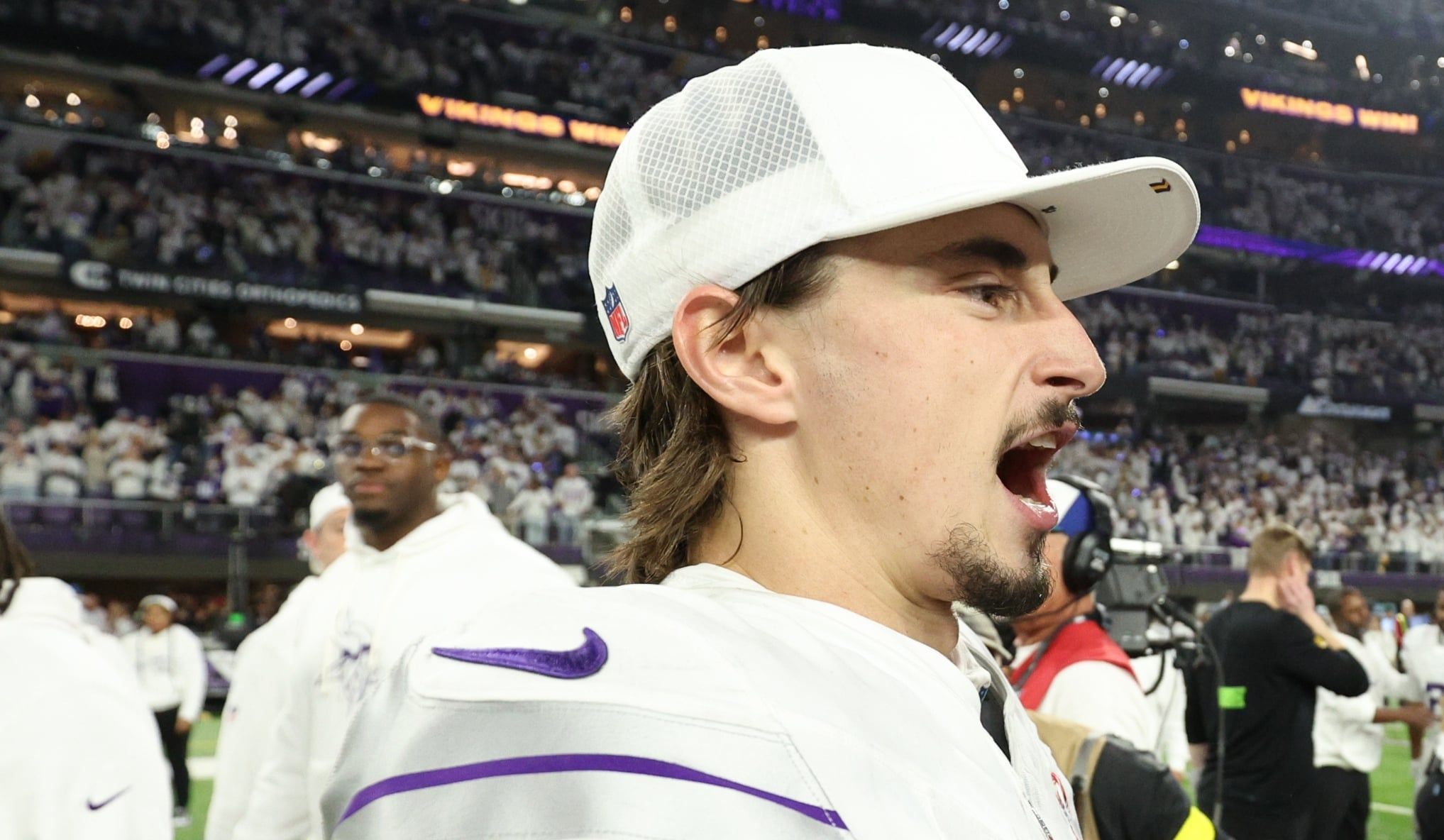 Vikings quarterback Max Brosmer and kicker Will Reichard interact on the field after a game at U.S. Bank Stadium.