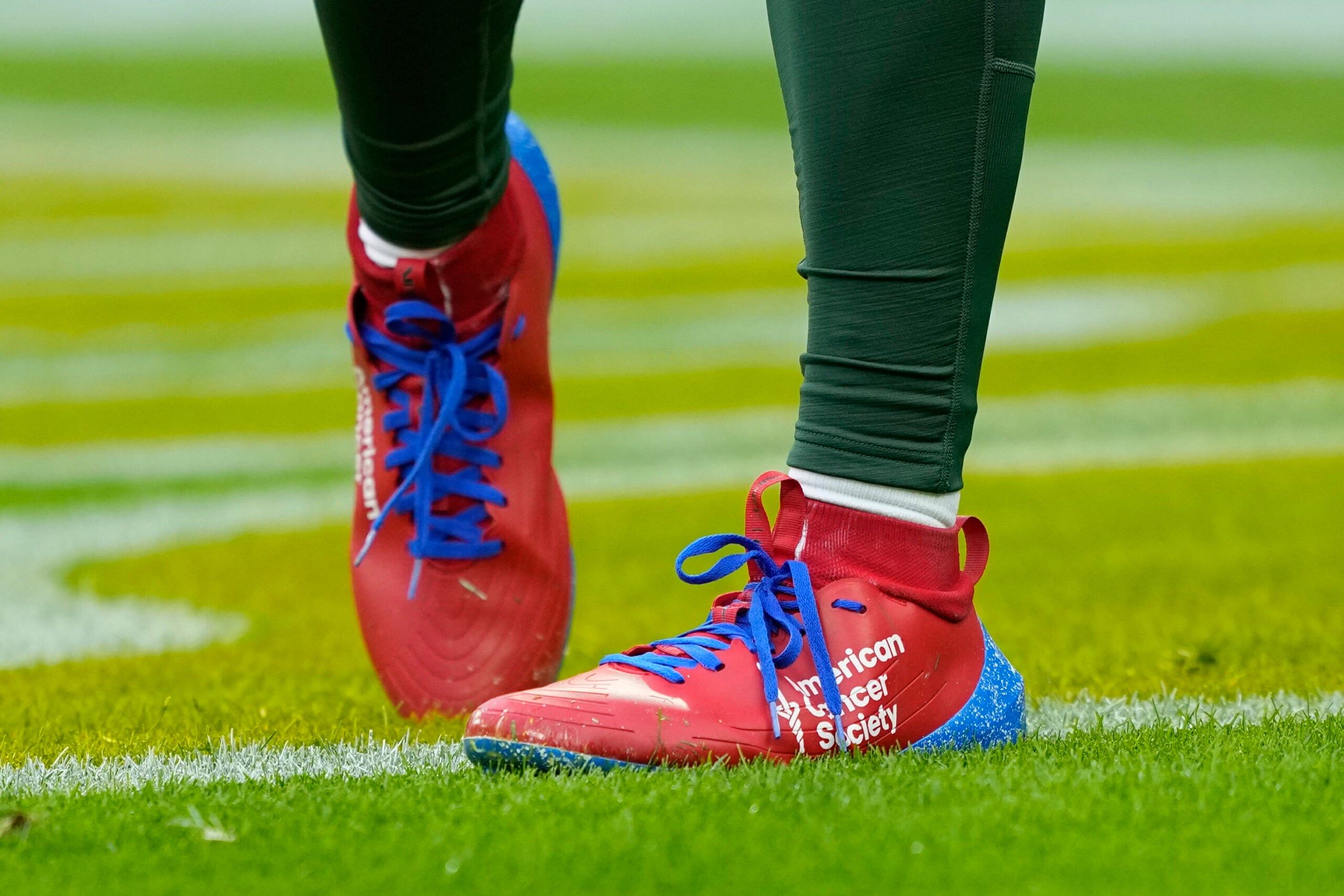 Malik Willis stands on the field before a Packers game at Lambeau Field.