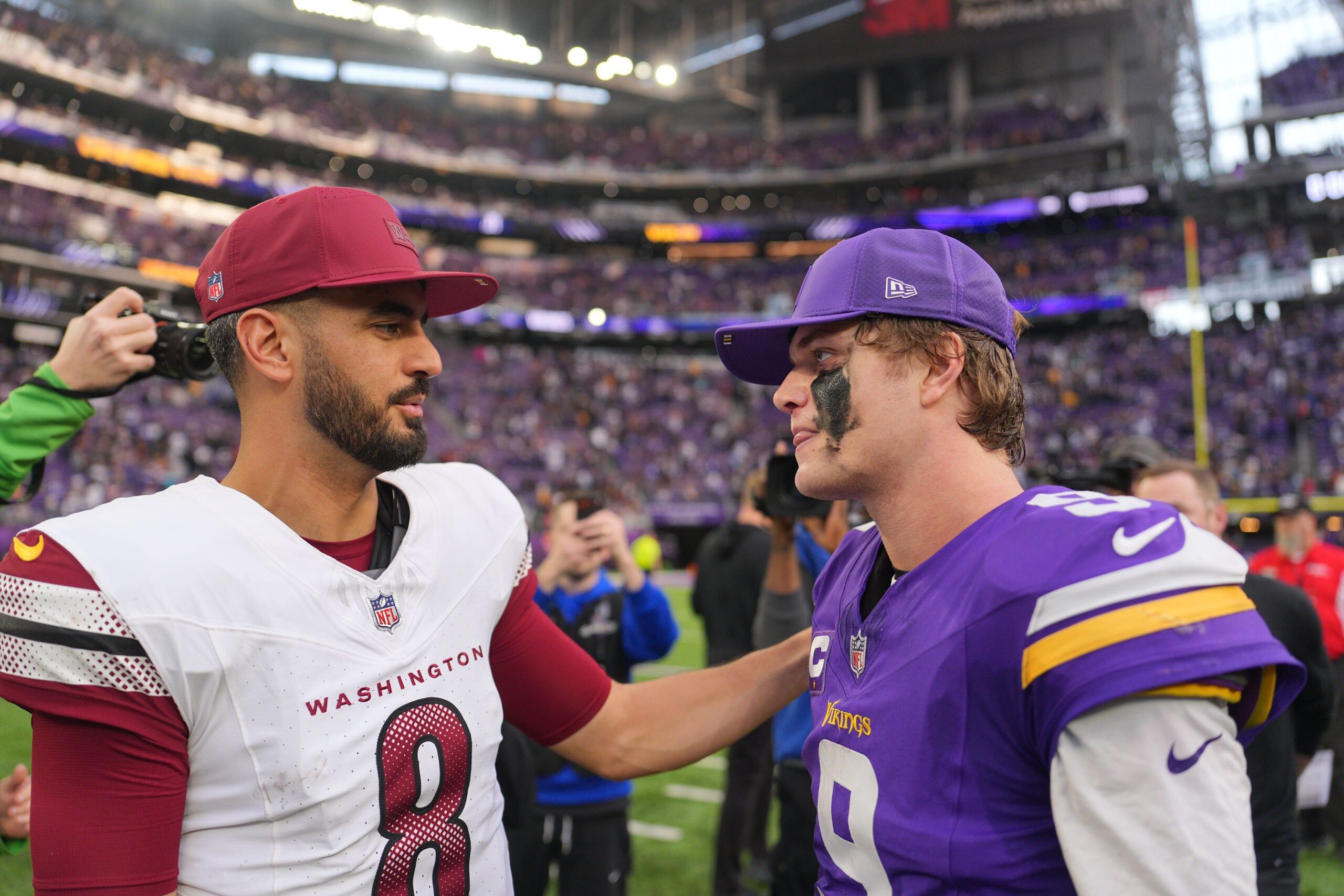 J.J. McCarthy and Marcus Mariota interact after a game at U.S. Bank Stadium