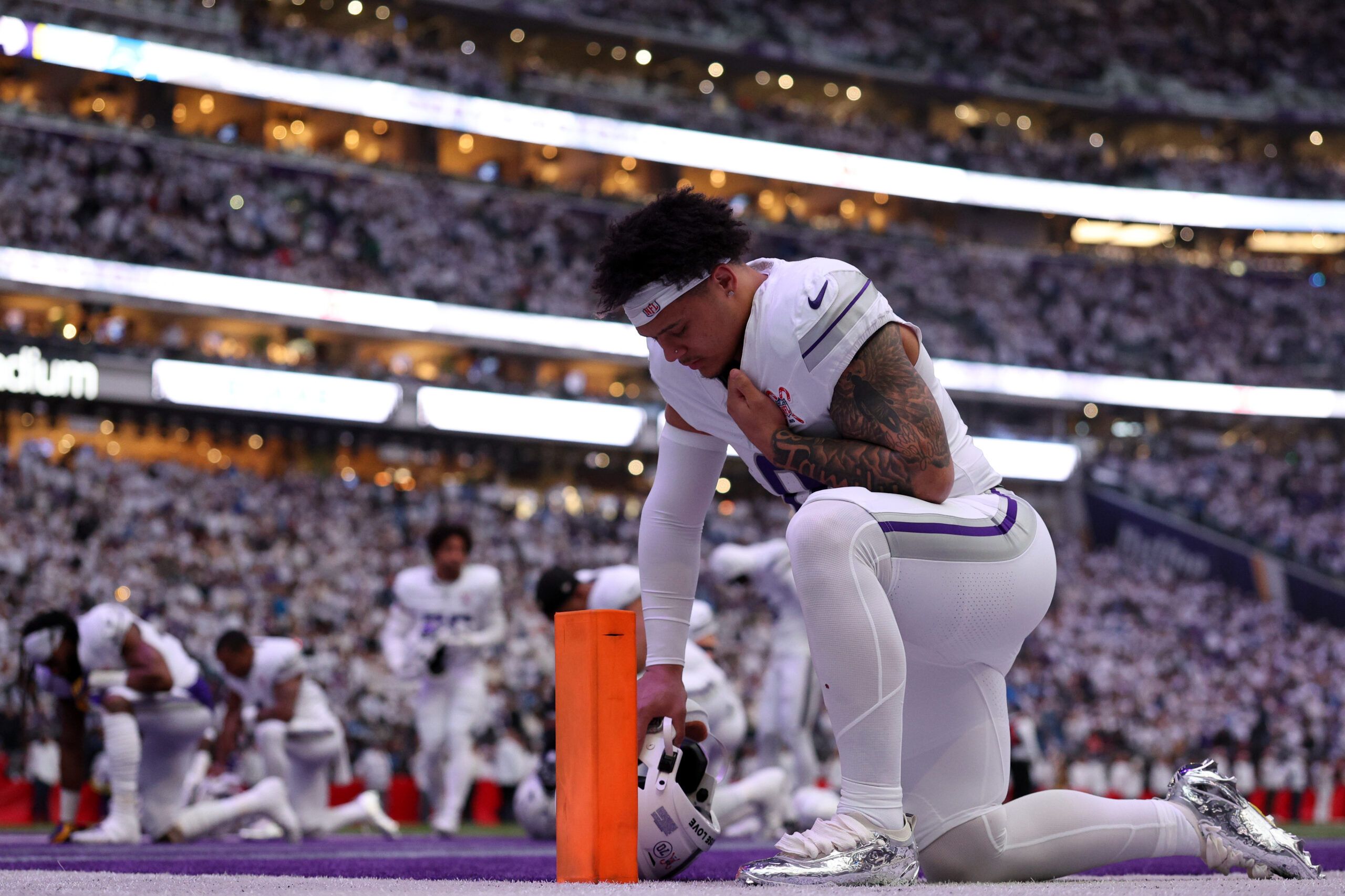 Ivan Pace Jr. kneels in the end zone before a Vikings game at U.S. Bank Stadium
