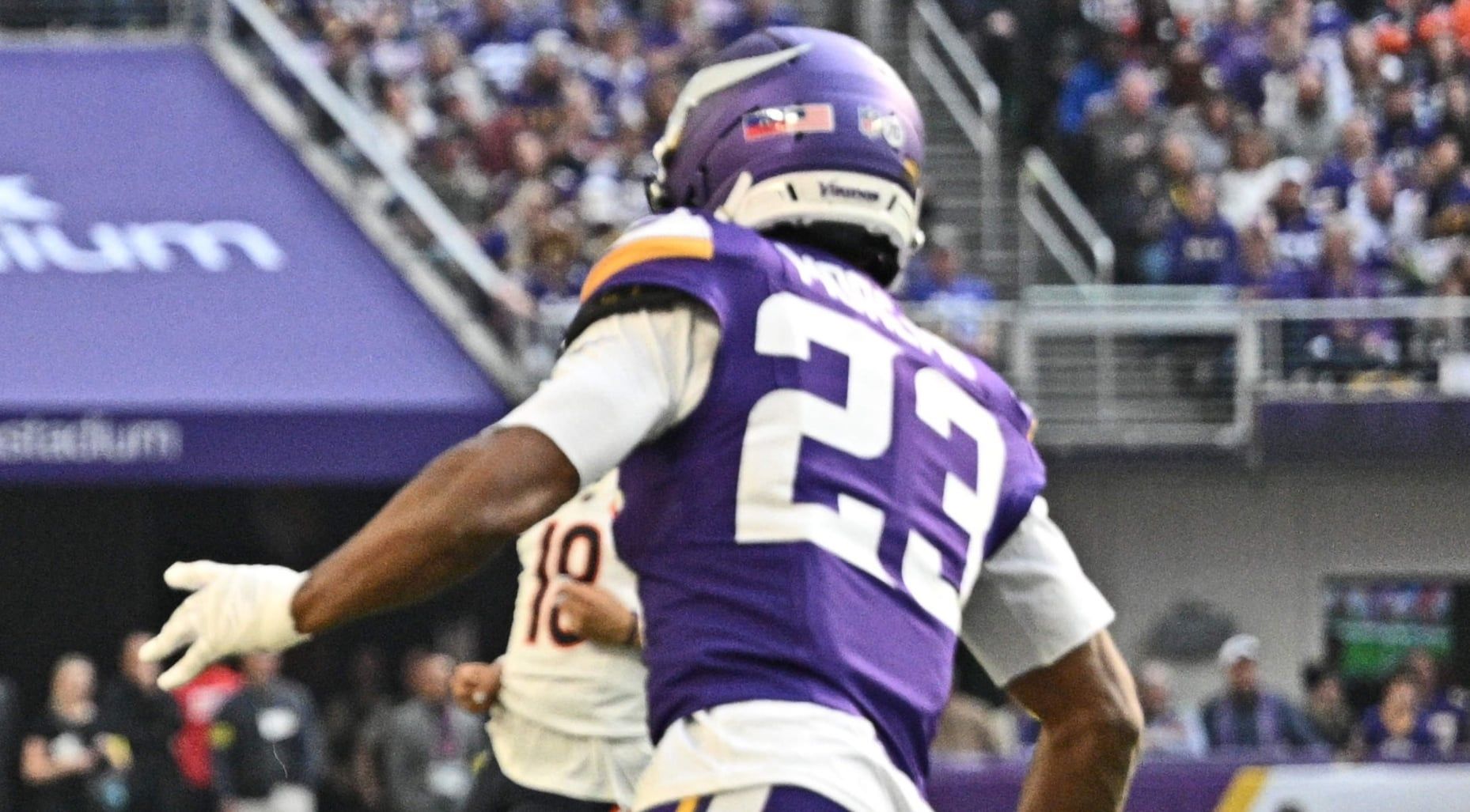 Colston Loveland runs with the ball for the Chicago Bears as Fabian Moreau pursues during a game at U.S. Bank Stadium.