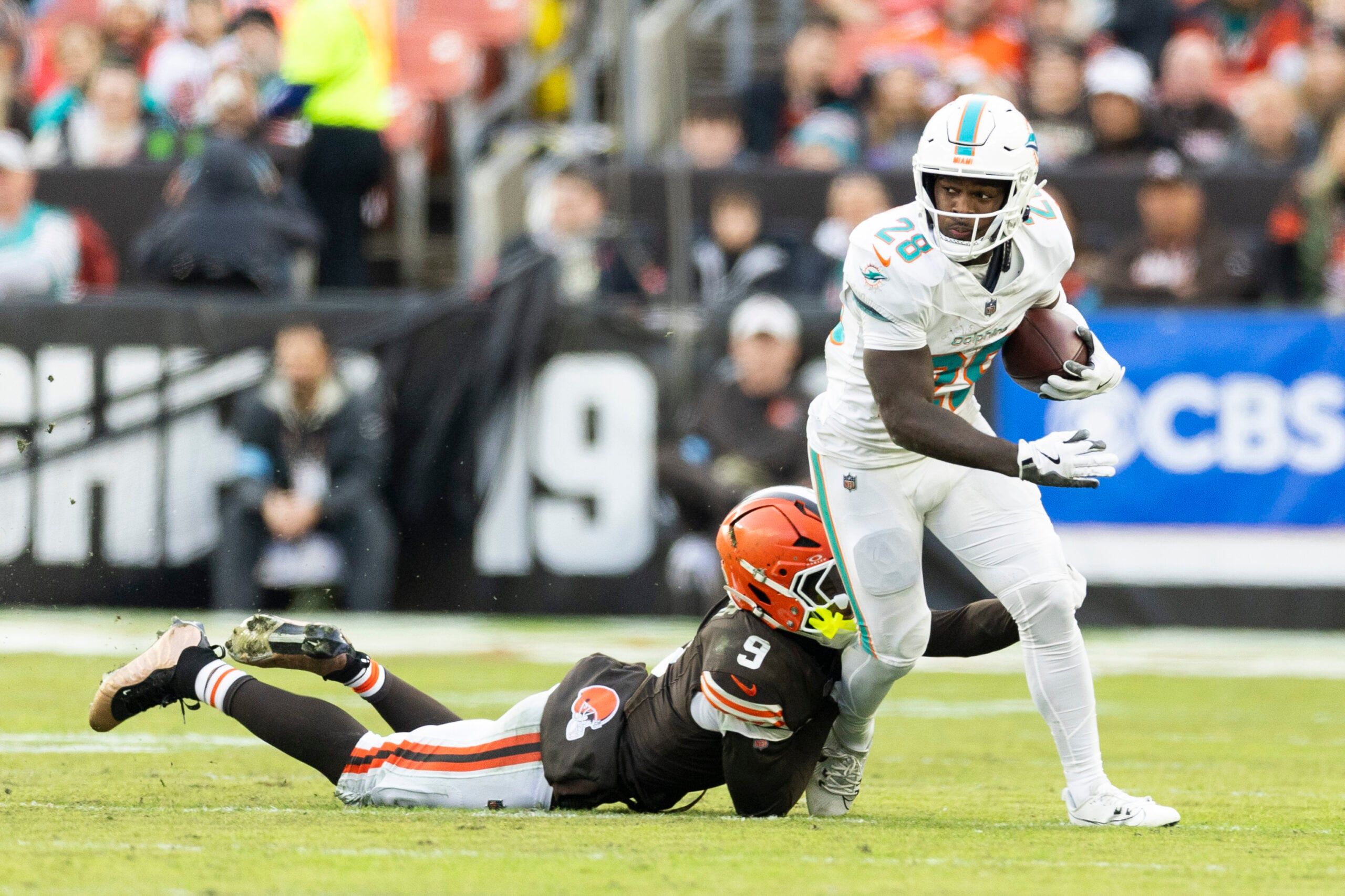 De’Von Achane is tackled by Grant Delpit while running the ball during a game in Cleveland.