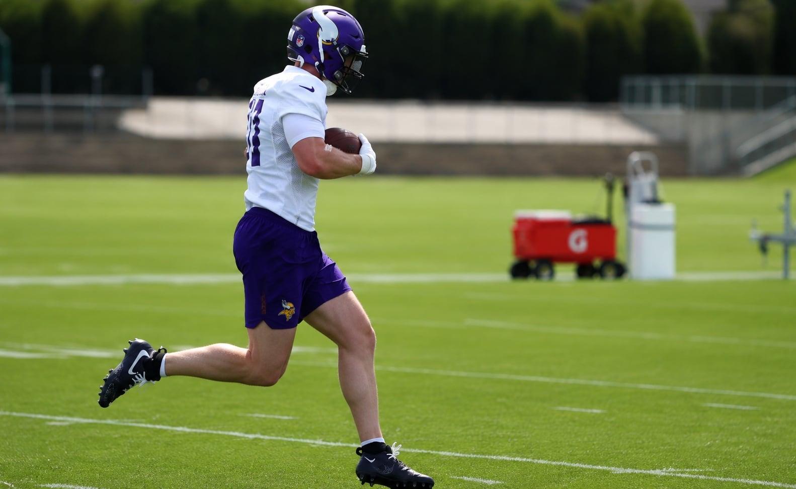 Jake Golday carries the football during Vikings minicamp practice in Eagan.
