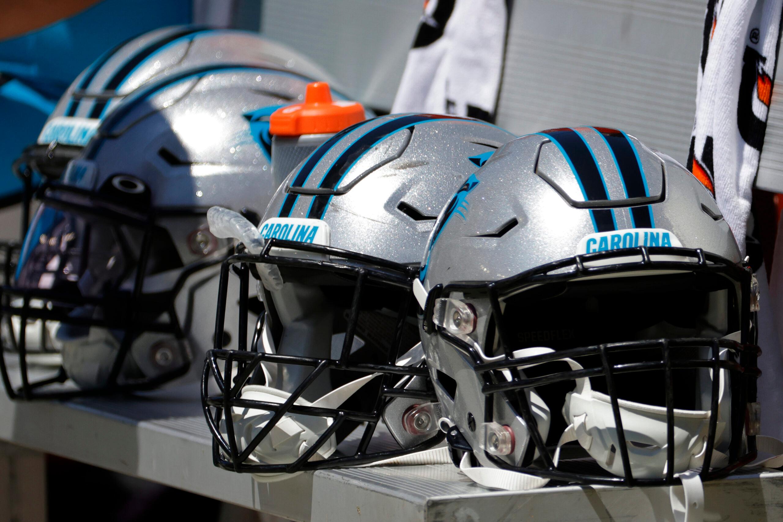 Carolina Panthers helmets sit on the sideline before a preseason game against the Commanders.