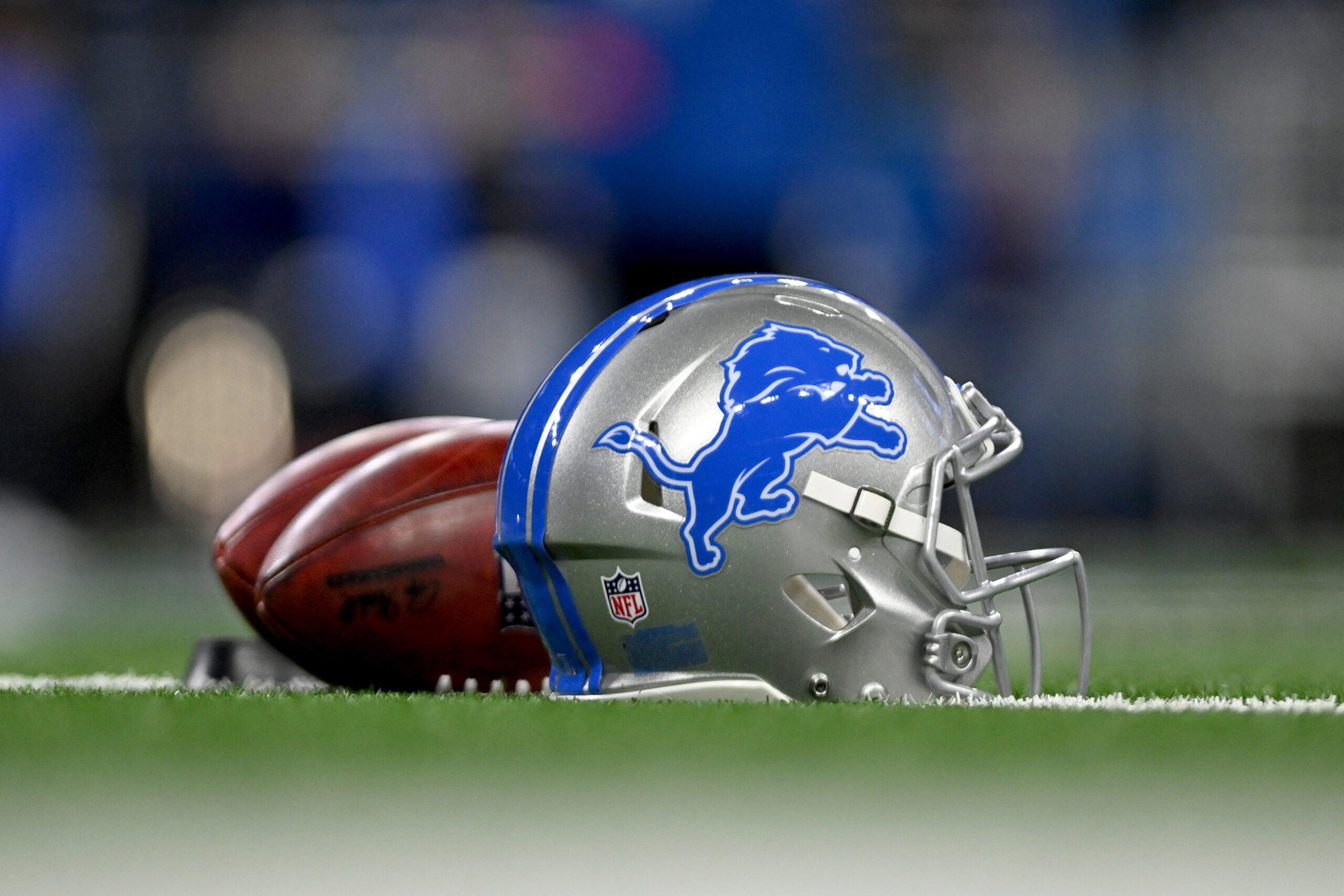 A Detroit Lions helmet and footballs rest on the field before an NFC Wild Card game at Ford Field.