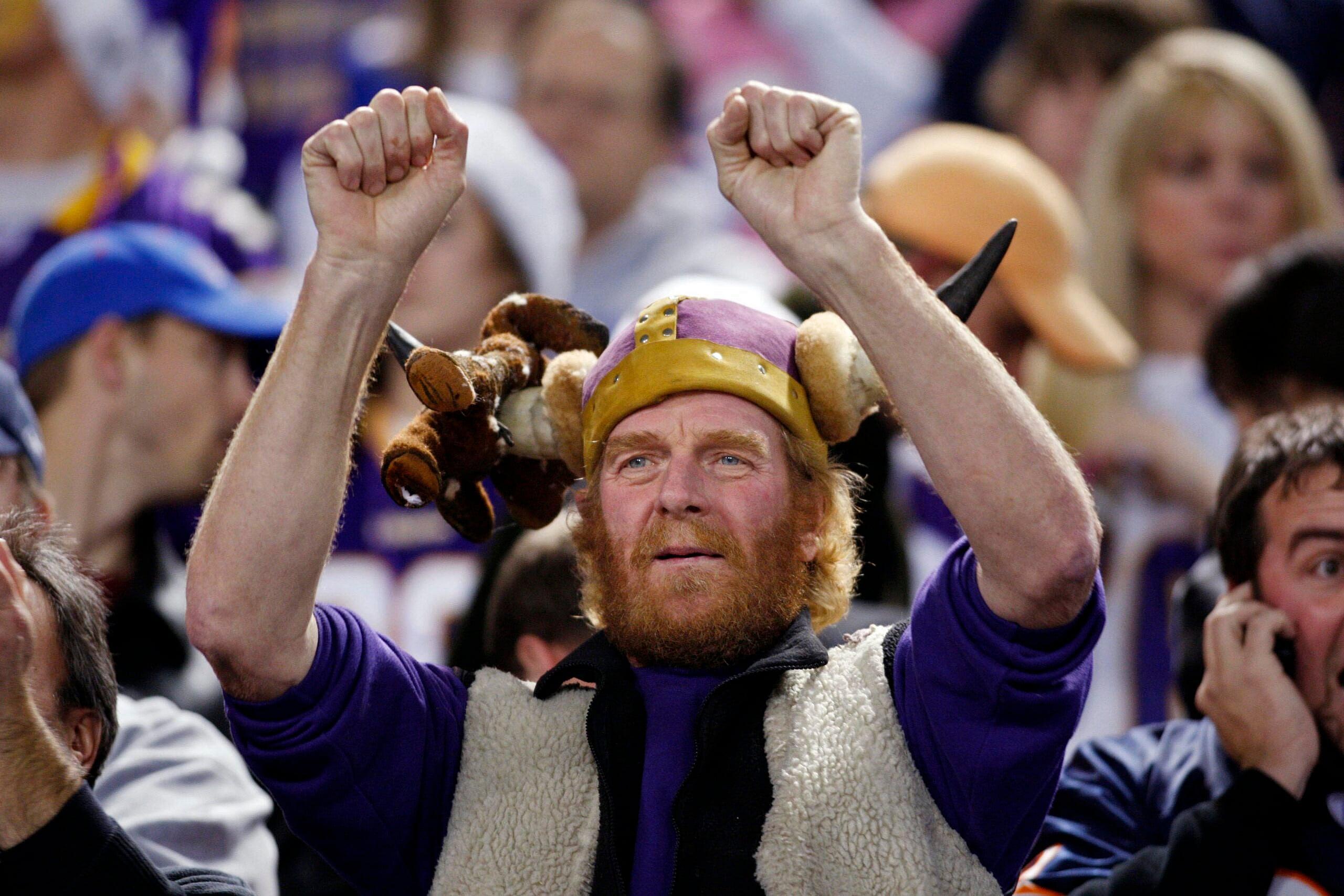 Vikings fan cheers with a bear speared on his helmet before a Bears game.