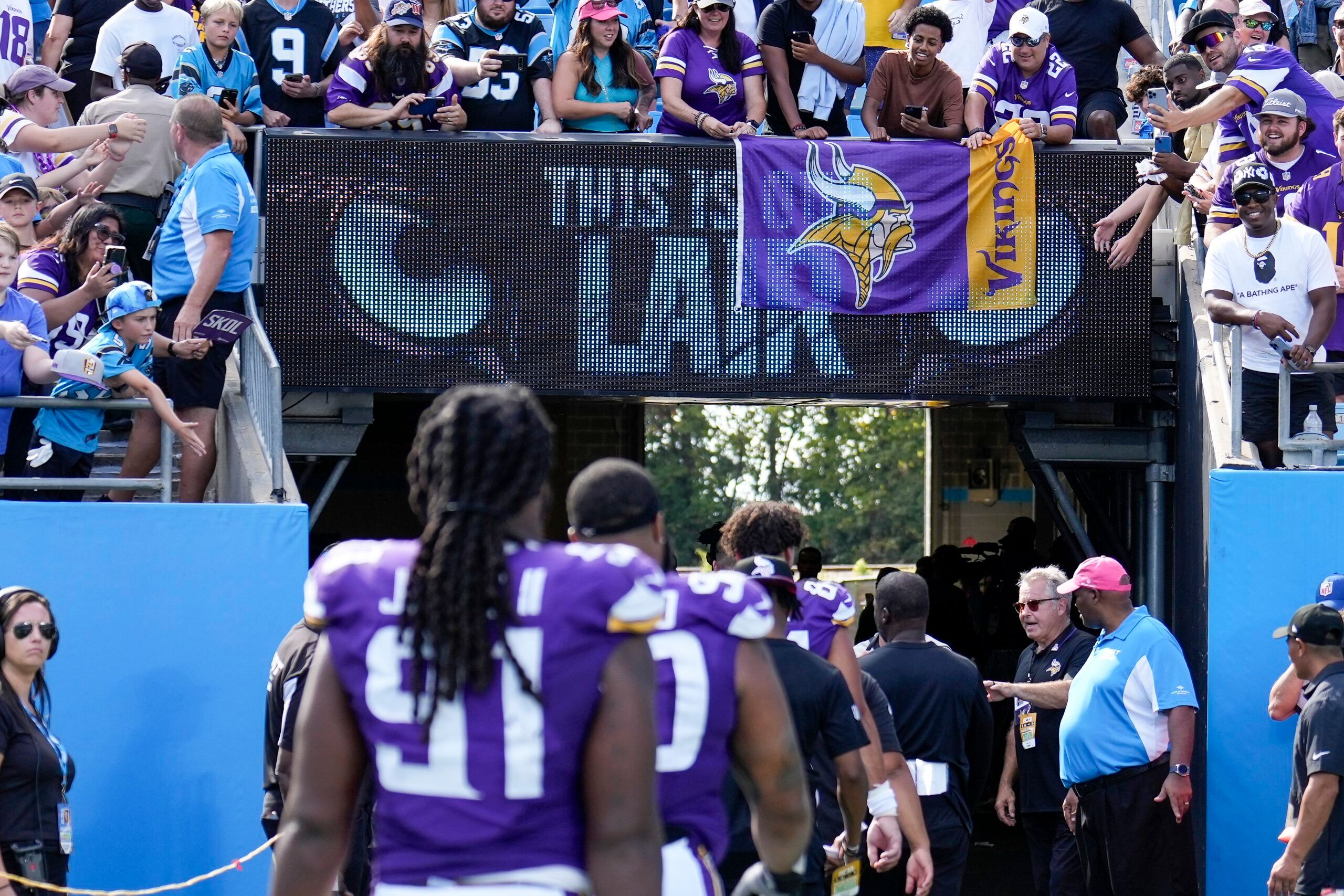 Minnesota Vikings fans cover signage while celebrating a win against the Panthers.