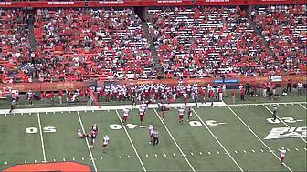 Football players in red and white jerseys on field during game.