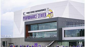 Twin Cities Orthopedics Performance Center exterior with Vikings logo and fans below.