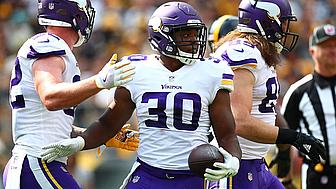 Minnesota Vikings player wearing #30 celebrates with teammates during game.