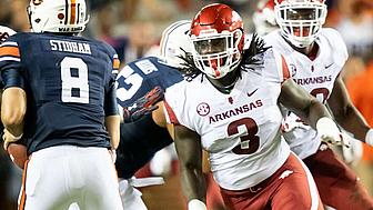 Arkansas defensive player in red jersey celebrates during college football game.