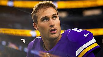 Vikings player in purple jersey on sideline during game.