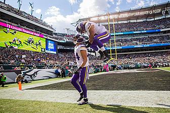 Minnesota Vikings player celebrates with ball in stadium during game.
