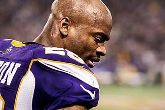 Minnesota Vikings player in purple jersey on sideline during game.