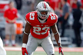 Football player wearing red jersey number 23 in defensive stance.