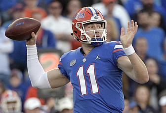 Football player in blue jersey number 11 throwing pass during game.