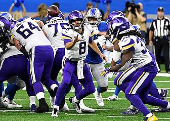Vikings quarterback number 8 drops back to pass during NFL game action.