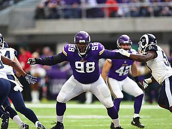 Vikings defensive lineman number 98 spreads arms wide during game action.