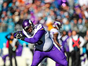 Minnesota Vikings player in purple jersey catching football during game.