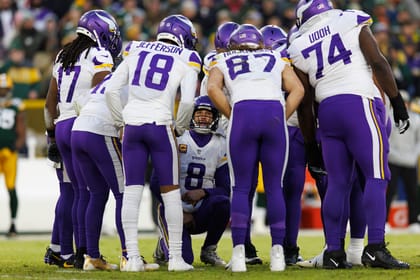 Kirk Cousins kneels in Vikings huddle vs. Packers at Lambeau Field.