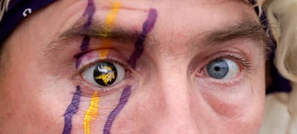 Vikings fan displaying a custom prosthetic eye with team logo at a fan event.