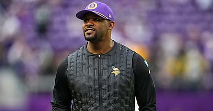 Vikings defensive coordinator Brian Flores stands on the field before a divisional matchup with Green Bay in Minneapolis.