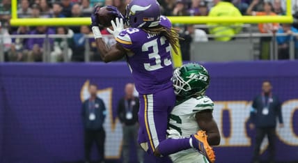 Aaron Jones catching a pass while Quincy Williams defends during a Vikings and Jets game in London.