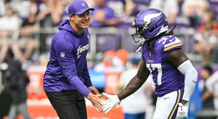 Kevin O'Connell speaks with Vikings cornerback Tavierre Thomas on the sideline before a preseason game against the Houston Texans.