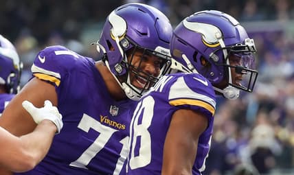 Christian Darrisaw, Justin Jefferson, and K.J. Osborn on the field during a Vikings–Packers game at U.S. Bank Stadium