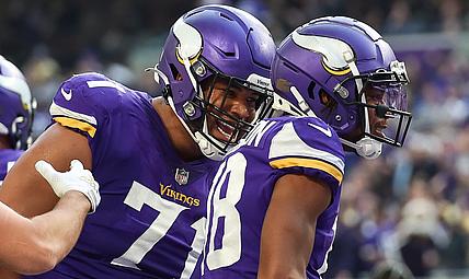 Christian Darrisaw, Justin Jefferson, and K.J. Osborn on the field during a Vikings–Packers game at U.S. Bank Stadium