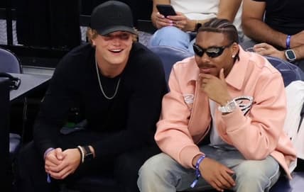 J.J. McCarthy and Justin Jefferson at a Timberwolves playoff game cheering courtside.