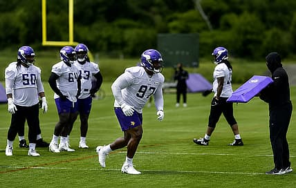 Domonique Orange attacks a blocking pad during Vikings minicamp.