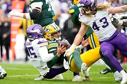 Dallas Turner sacks Jordan Love during a Vikings-Packers game at Lambeau Field.
