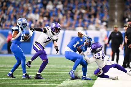 Amon-Ra St. Brown is pushed out of bounds by Jonathan Greenard during a game