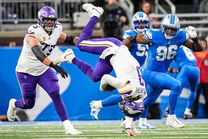 J.J. McCarthy flips after a tackle by Detroit’s Jack Campbell at Ford Field.