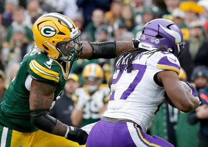 Vikings running back Jordan Mason carries the ball against Packers defender Micah Parsons at Lambeau Field.