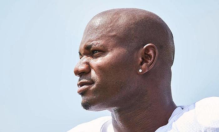 Man in white shirt shown in profile against clear sky background.