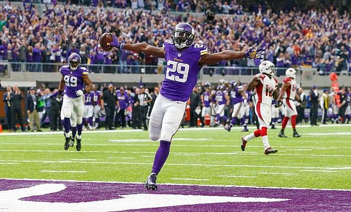 Vikings player number 29 celebrates touchdown in end zone at home stadium.