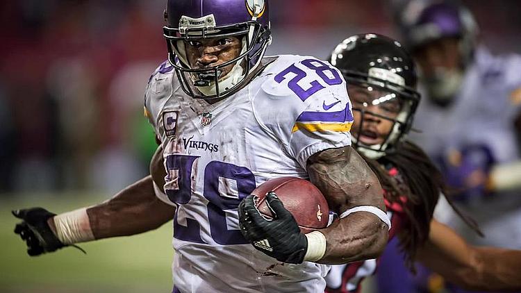 Minnesota Vikings running back carries football during game action.