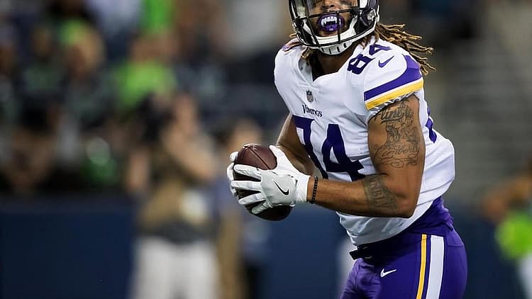 Minnesota Vikings player running with football during game.