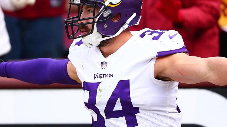 Minnesota Vikings player number 74 celebrates with arms raised during game.