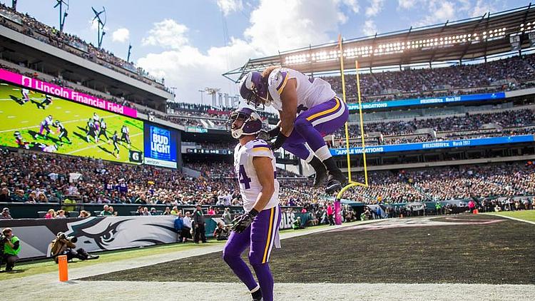 Minnesota Vikings player celebrates with ball in stadium during game.